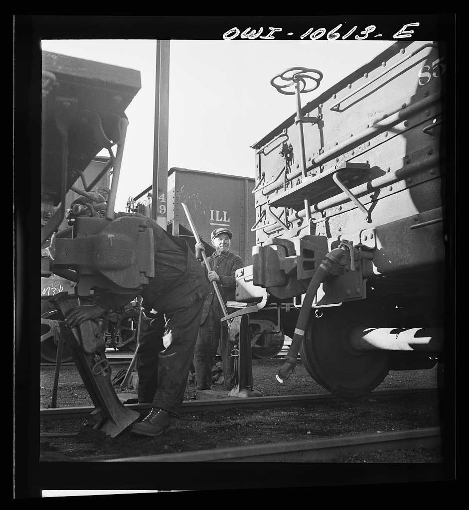 Jacking up a car on the repair tracks at an Illinois Central Railroad yard, Chicago, Chicago, 1942