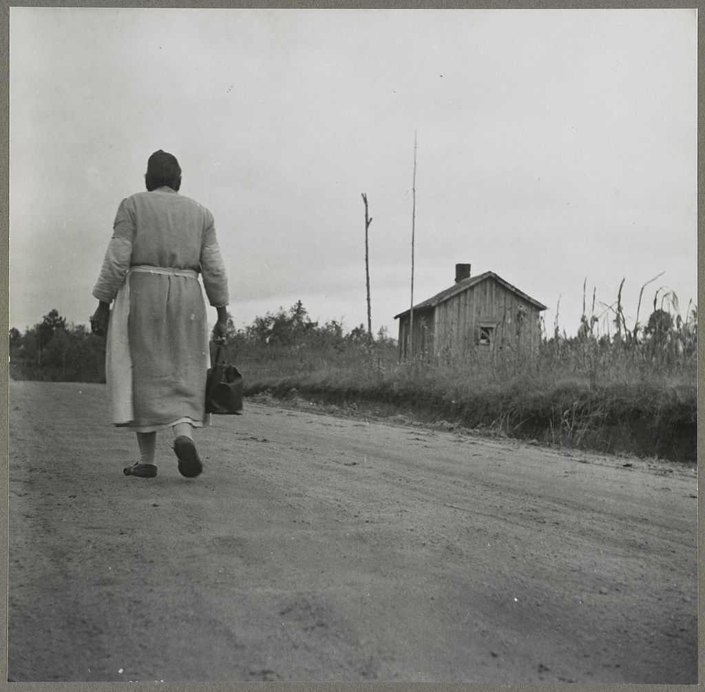 A Black midwife walks a dirt road near Siloam, Greene County, Georgia, carrying her kit on her way to a call, November 1941 (Jack Delano, FSA-OWI) — CultureTechLens