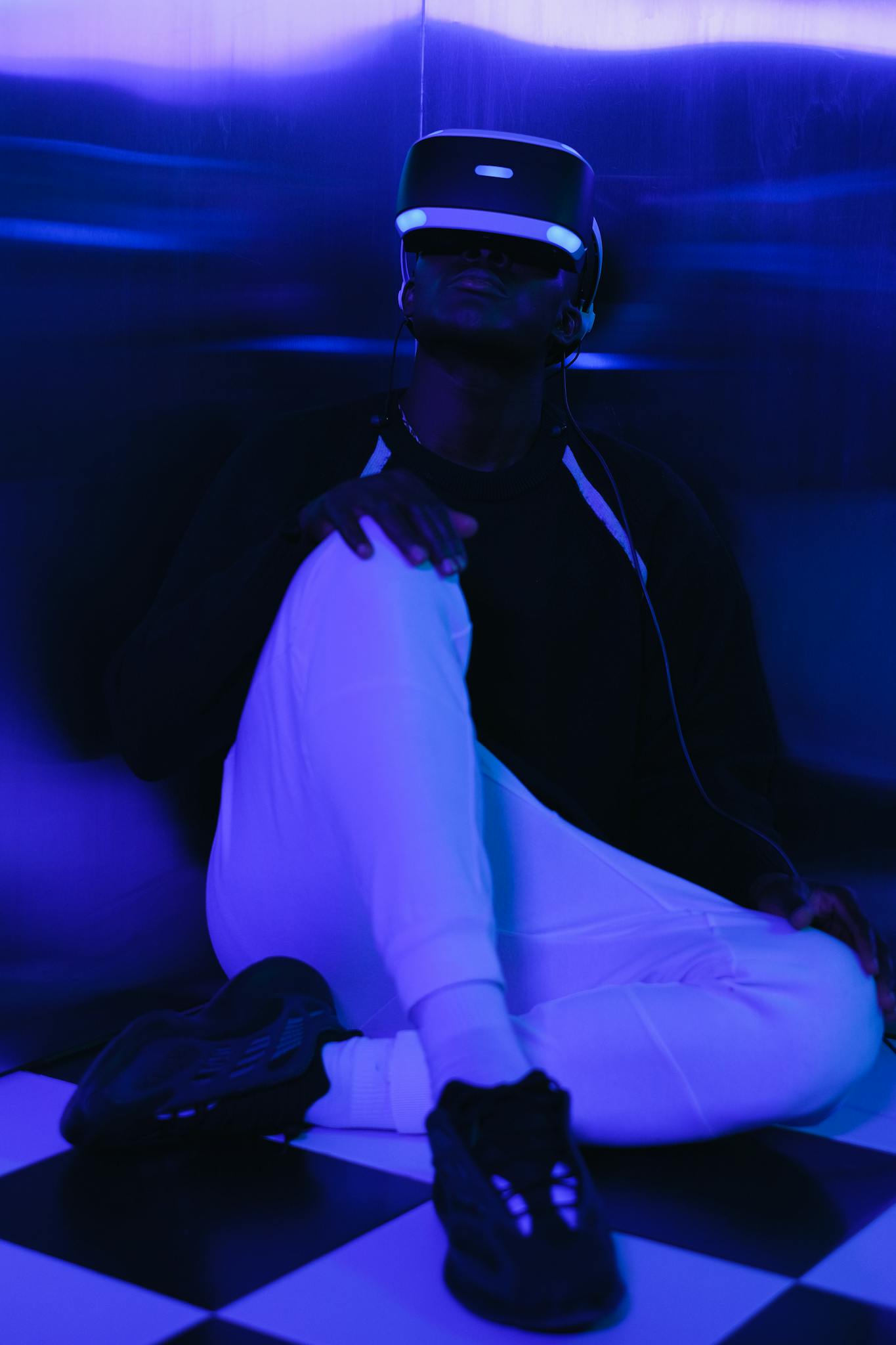 A person enjoying virtual reality in a neon-lit room, wearing a VR headset.