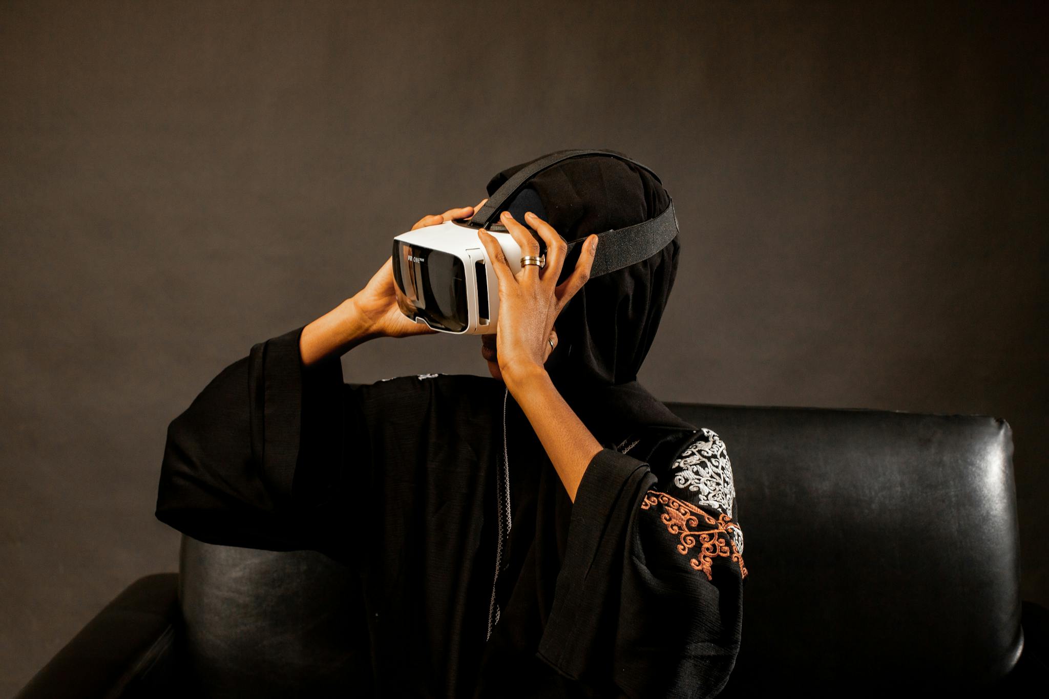 A woman in traditional dress immersed in virtual reality with VR headset indoors.