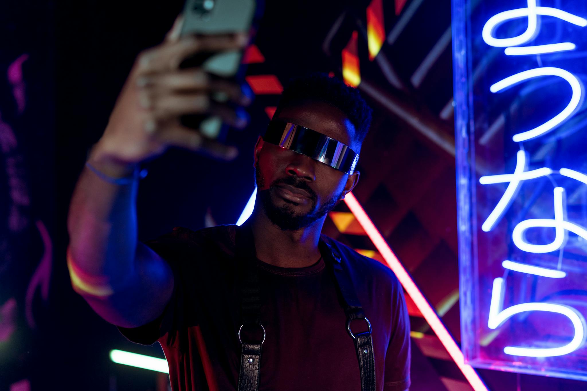 Cyberpunk-inspired selfie with neon lights and futuristic sunglasses.